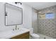 Updated bathroom with a marble countertop, decorative mirror and patterned tile and an updated shower at 5738 E Cicero Rd, Mesa, AZ 85205