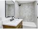 Bathroom featuring a marble countertop, modern black faucet, and shower over tub with nice tile at 5738 E Cicero Rd, Mesa, AZ 85205