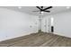 Spacious bedroom with hardwood floors, ceiling fan, neutral paint, and two entry doors at 5738 E Cicero Rd, Mesa, AZ 85205