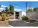 Storage shed in the backyard with open door, stone covering the ground at 5738 E Cicero Rd, Mesa, AZ 85205