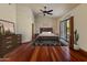 Bright bedroom features a ceiling fan, a sliding glass door, and beautiful wood floors at 5830 E Restin Rd, Carefree, AZ 85377