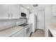 Efficient kitchen featuring white cabinets, tiled floors and countertops, with a microwave over the range at 6270 N 78Th St # 323, Scottsdale, AZ 85250