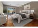 Bright main bedroom with hardwood floors, a sliding glass door, and a modern chandelier at 6302 N 4Th Dr, Phoenix, AZ 85013