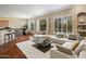 Open-concept living room with hardwood floors, a wet bar, modern furniture, and large bright windows at 6302 N 4Th Dr, Phoenix, AZ 85013