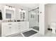 Bathroom with dual vanity, white cabinets and marble surround glass shower at 7028 N 12Th Way, Phoenix, AZ 85020