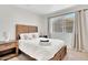 Bedroom with a wood frame bed, plush carpet and natural light from a large window at 7028 N 12Th Way, Phoenix, AZ 85020