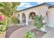 Inviting front entrance with arched brickwork, a brick walkway and lush landscaping at 7028 N 12Th Way, Phoenix, AZ 85020