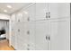 A bright pantry features white cabinets with sleek hardware and hardwood floors at 7028 N 12Th Way, Phoenix, AZ 85020