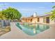An inground pool with floaties features a covered patio and mature trees at 7028 N 12Th Way, Phoenix, AZ 85020