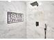 Walk-in shower with black fixtures, marble tile and recessed niche at 7028 N 12Th Way, Phoenix, AZ 85020