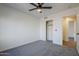 This bright bedroom features neutral paint, a ceiling fan, and a closet for storage at 72 S Willow Creek St, Chandler, AZ 85225