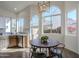 Sunlit breakfast nook features a round table with metal chairs beneath a modern light fixture and view of the yard at 72 S Willow Creek St, Chandler, AZ 85225