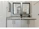 Bathroom featuring double sinks with granite countertops, white cabinetry, and framed mirrors at 7807 W Palm Ln, Phoenix, AZ 85035