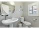 Elegant bathroom with a pedestal sink, round mirror, and stylish fixtures at 7807 W Palm Ln, Phoenix, AZ 85035