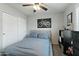 Bedroom featuring a ceiling fan, closet, and a black and white poster of a motorcycle on the wall at 7807 W Palm Ln, Phoenix, AZ 85035