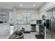 Bright kitchen featuring white cabinetry, stainless steel appliances, and grey and white countertops at 7807 W Palm Ln, Phoenix, AZ 85035