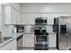 Bright kitchen featuring white cabinetry, stainless steel appliances and grey and white countertops at 7807 W Palm Ln, Phoenix, AZ 85035