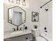 Bathroom featuring granite counters, updated fixtures, hexagon mirror, and tub with tile surround at 9429 E Nacoma Dr, Sun Lakes, AZ 85248