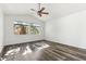 Bedroom features modern ceiling fan, neutral paint, and wood-look floors with view to backyard at 9429 E Nacoma Dr, Sun Lakes, AZ 85248