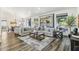 Bright living room featuring hardwood floors, neutral furniture, a large rug and sliding glass doors at 9429 E Nacoma Dr, Sun Lakes, AZ 85248