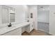 Bathroom with dual sinks, stylish mirrors, quartz counters, and modern fixtures at 9522 W Luxton Ln, Tolleson, AZ 85353