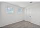 Bright bedroom featuring plush carpeting, white walls, and two windows at 9522 W Luxton Ln, Tolleson, AZ 85353