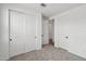 Carpeted bedroom with closet doors and a door leading to a hallway at 9522 W Luxton Ln, Tolleson, AZ 85353