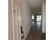 Hallway showcasing wood-look flooring and leading to a bright living area with sliding glass doors at 9522 W Luxton Ln, Tolleson, AZ 85353