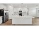 Modern kitchen with stainless steel appliances, white cabinetry, mosaic backsplash and an island at 9522 W Luxton Ln, Tolleson, AZ 85353