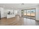 Open-concept living space with wood-look tile flooring, a kitchen, and sliding glass doors to the backyard at 9522 W Luxton Ln, Tolleson, AZ 85353