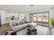 Staged open-concept living space with wood-look tile flooring, a kitchen, and contemporary furniture at 9522 W Luxton Ln, Tolleson, AZ 85353