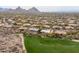 An aerial view showcasing a desert home community alongside a well-manicured golf course at 9626 E Peak View Rd, Scottsdale, AZ 85262