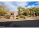 Charming home featuring desert landscaping, a stone facade, and mature trees providing shade and curb appeal at 9626 E Peak View Rd, Scottsdale, AZ 85262