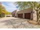 Spacious three-car garage with dark wood doors and desert landscaping at 9626 E Peak View Rd, Scottsdale, AZ 85262