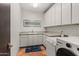 Well-equipped laundry room with modern washer and dryer, ample counter space, and storage cabinets at 9626 E Peak View Rd, Scottsdale, AZ 85262
