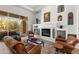 Cozy living room featuring a fireplace, built-in shelving, and access to the outdoor patio at 9626 E Peak View Rd, Scottsdale, AZ 85262