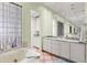 This luxury main bathroom features a soaking tub, granite counters, and lots of mirrored storage at 9626 E Peak View Rd, Scottsdale, AZ 85262