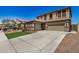 Exterior view of home showcasing a wide driveway, two-car garage, and tidy front lawn at 11728 W Villa Hermosa N Ln, Sun City, AZ 85373