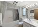 Well-lit bathroom with a shower-tub combination featuring stylish curtain and vanity with white countertops at 12814 W Shadow Hills Dr, Sun City West, AZ 85375