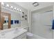 Bathroom with a large mirror and a walk-in shower framed in a white tile surround at 12814 W Shadow Hills Dr, Sun City West, AZ 85375