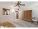 Bright bedroom with a ceiling fan, decorative armoire, and striped bedding for a cozy and inviting space at 12814 W Shadow Hills Dr, Sun City West, AZ 85375