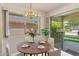 Cozy dining area with a round table, stylish lighting, and seamless access to the outdoor patio at 12814 W Shadow Hills Dr, Sun City West, AZ 85375