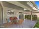 Relaxing covered patio featuring wicker furniture and seamless indoor-outdoor transition with sliding glass door at 12814 W Shadow Hills Dr, Sun City West, AZ 85375