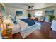 A spacious, staged main bedroom with hardwood floors, ceiling fan, and serene light-blue accents at 1541 W Culver St, Phoenix, AZ 85007