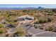 Aerial view of the home showing desert landscaping, three car garage, and a circle driveway at 16141 E Thistle Dr, Fountain Hills, AZ 85268