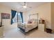 Cozy bedroom with a metal framed bed, colorful pillows, and a window with blue drapes at 16141 E Thistle Dr, Fountain Hills, AZ 85268