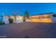 Desert home featuring a three-car garage and a spacious brick driveway at dusk at 16141 E Thistle Dr, Fountain Hills, AZ 85268