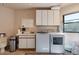 Functional laundry room with modern washer and dryer, ample storage, and a sink at 16141 E Thistle Dr, Fountain Hills, AZ 85268