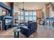 Large living room with a fireplace, comfortable seating, and scenic views from the expansive windows at 16141 E Thistle Dr, Fountain Hills, AZ 85268