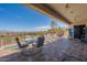 Covered patio boasts a dining area, comfortable seating, and panoramic mountain views at 16141 E Thistle Dr, Fountain Hills, AZ 85268